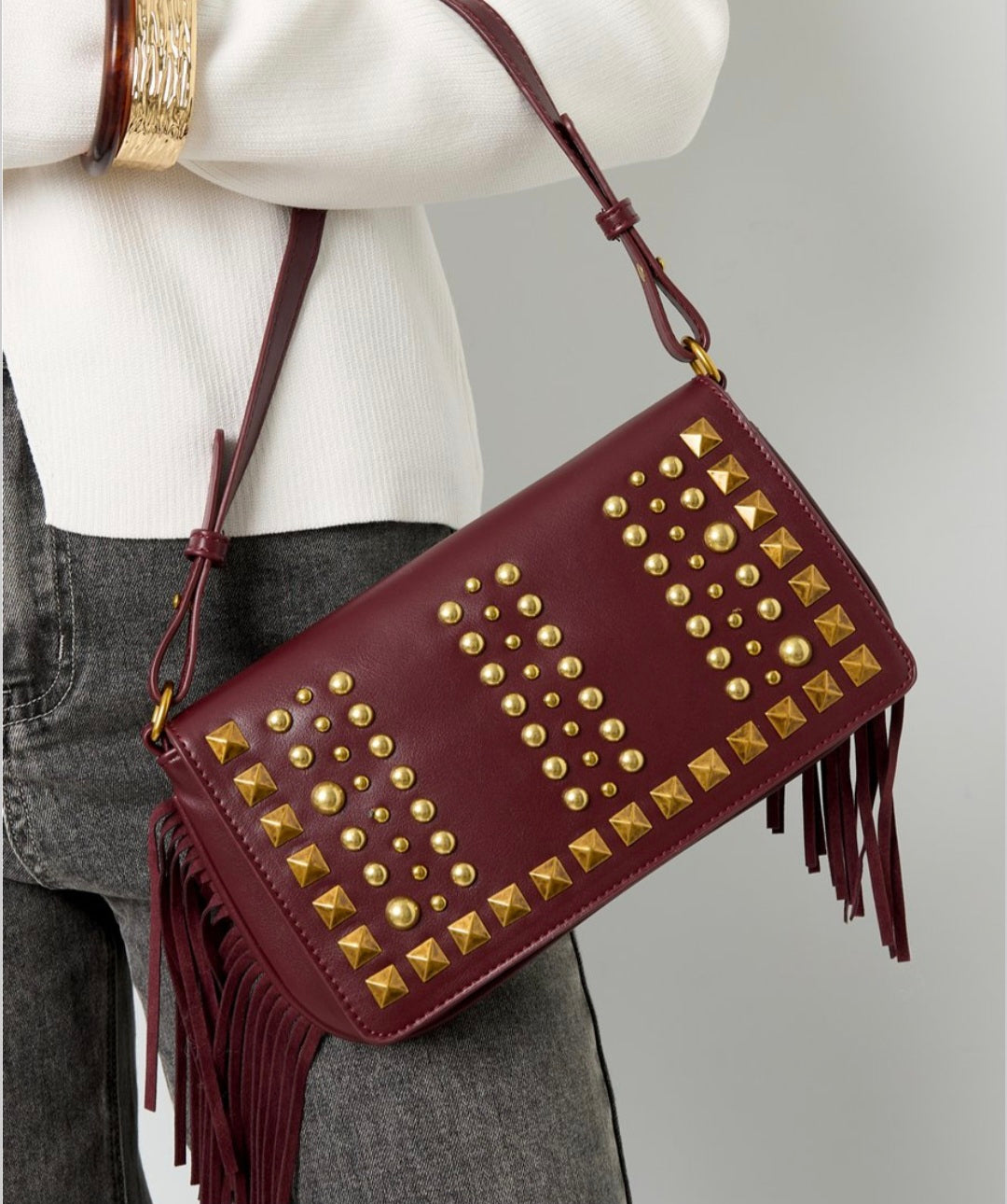 Tas  bordeaux rood met studs en franje.